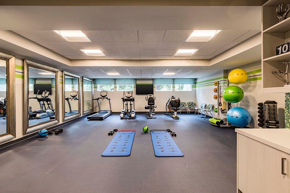 A modern, well-equipped gym with exercise machines, yoga mats, and fitness accessories.