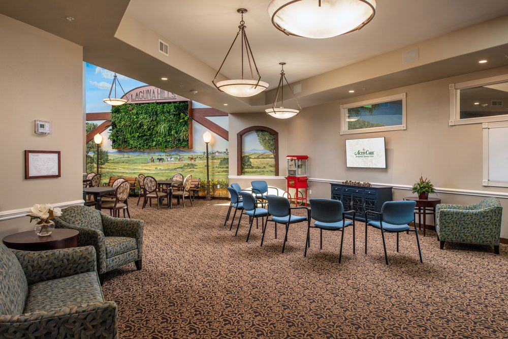 A cozy indoor lounge area featuring comfortable seating, tables, decorative lighting, and artwork on the walls.