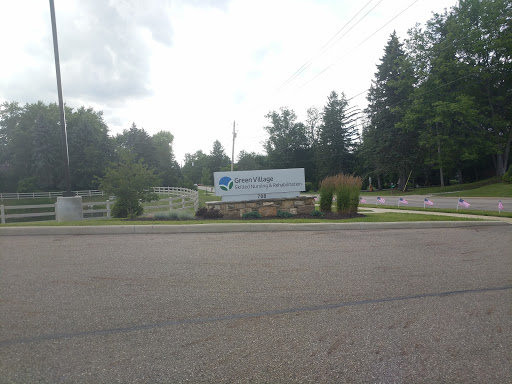 A business sign set against a backdrop of trees by the roadside.
