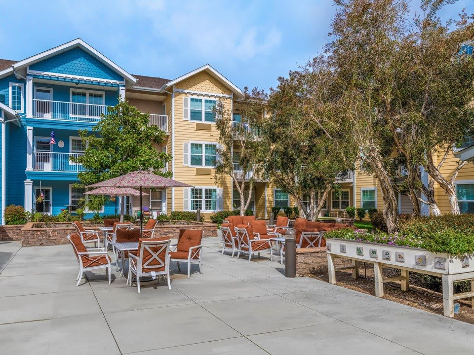 A modern apartment complex with outdoor seating on a sunny day.