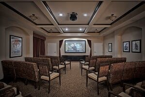 A cozy home theater room with arranged seating and a large screen.