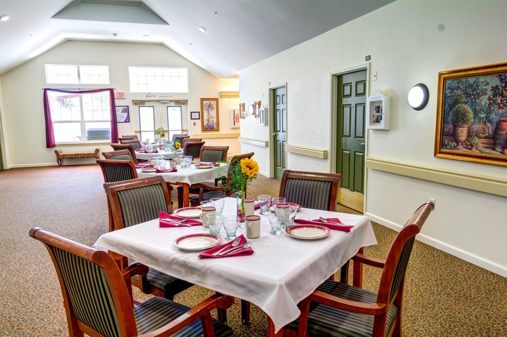 A cozy dining room with neatly set tables and sunflower centerpieces.