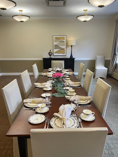 An elegantly set dining table, complete with fine china and a decorative floral centerpiece.
