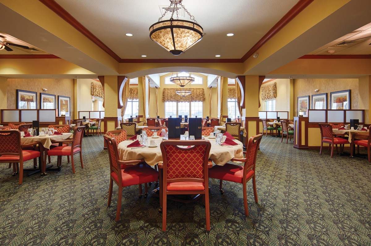 An elegant dining room with beautifully set tables and warm lighting.