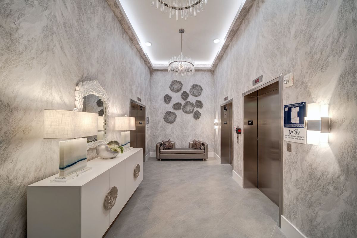A sophisticated lobby with modern design elements, featuring elevators and stylish decor.