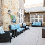 A modern patio with comfortable seating and brick walls.