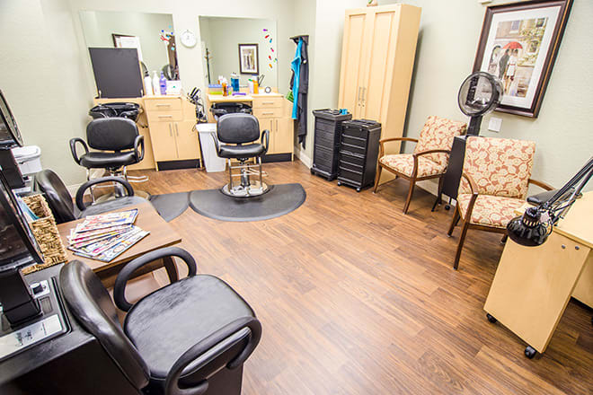 A bright and tidy hair salon with multiple styling stations and comfortable chairs.