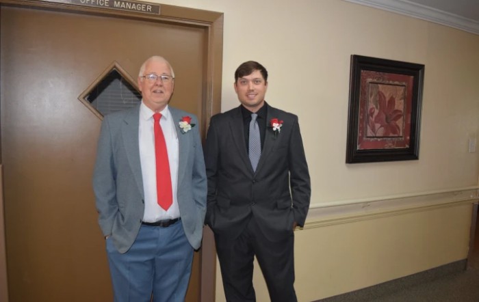 Two men in formal attire standing indoors.