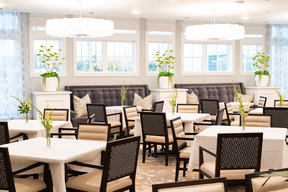 A modern and elegant dining room with neatly arranged tables and chairs.