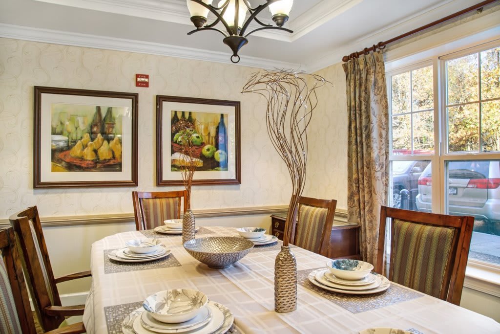A beautifully set dining room table with elegant decor and artwork.