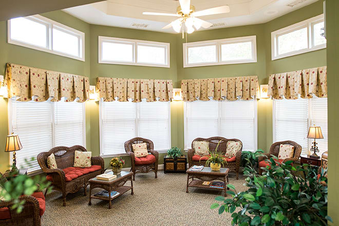 A cozy living room with ample seating and natural light from large windows.