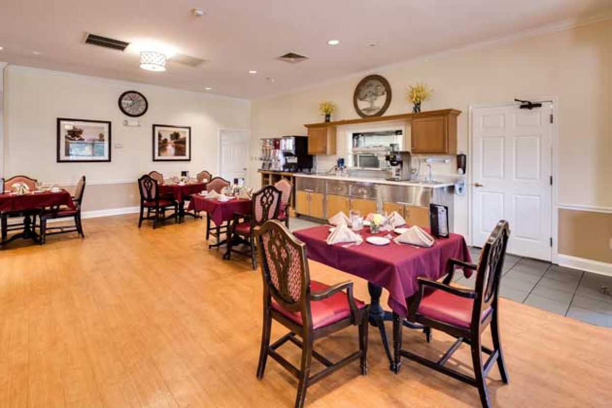 A cozy dining area with elegantly set tables, wooden flooring, and tasteful decor.