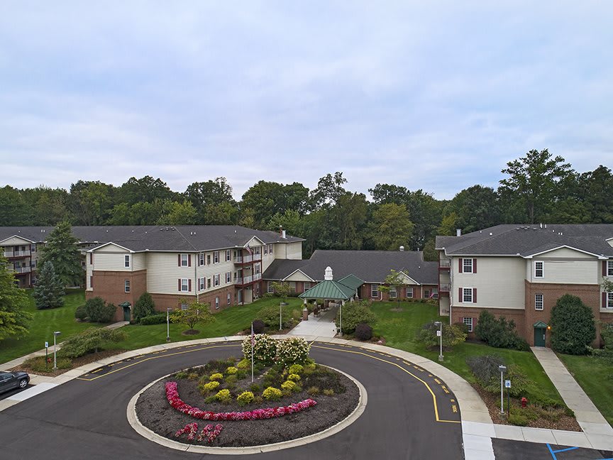 Aerial view of a residential complex with landscaped gardens and a roundabout.