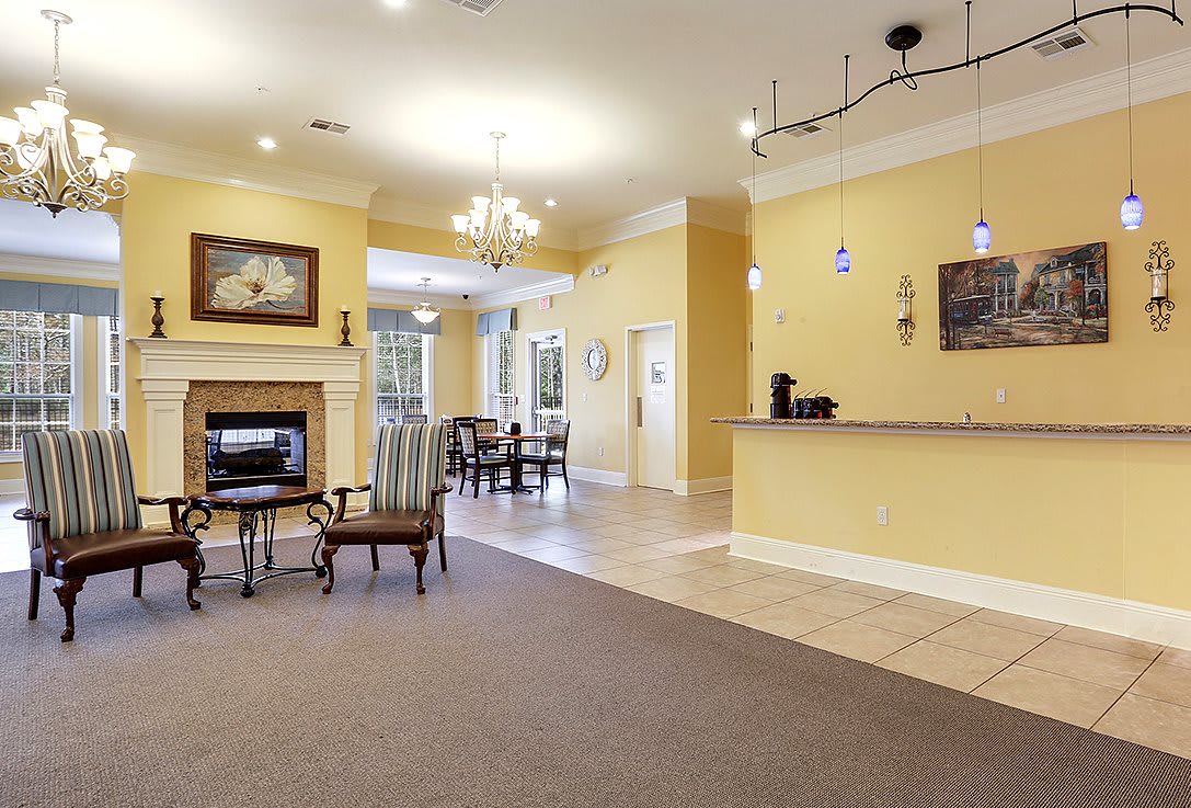 A welcoming lobby with a seating area, chandelier, and fireplace.