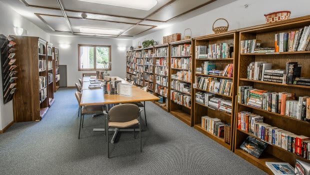 A cozy library with bookshelves and a reading table.