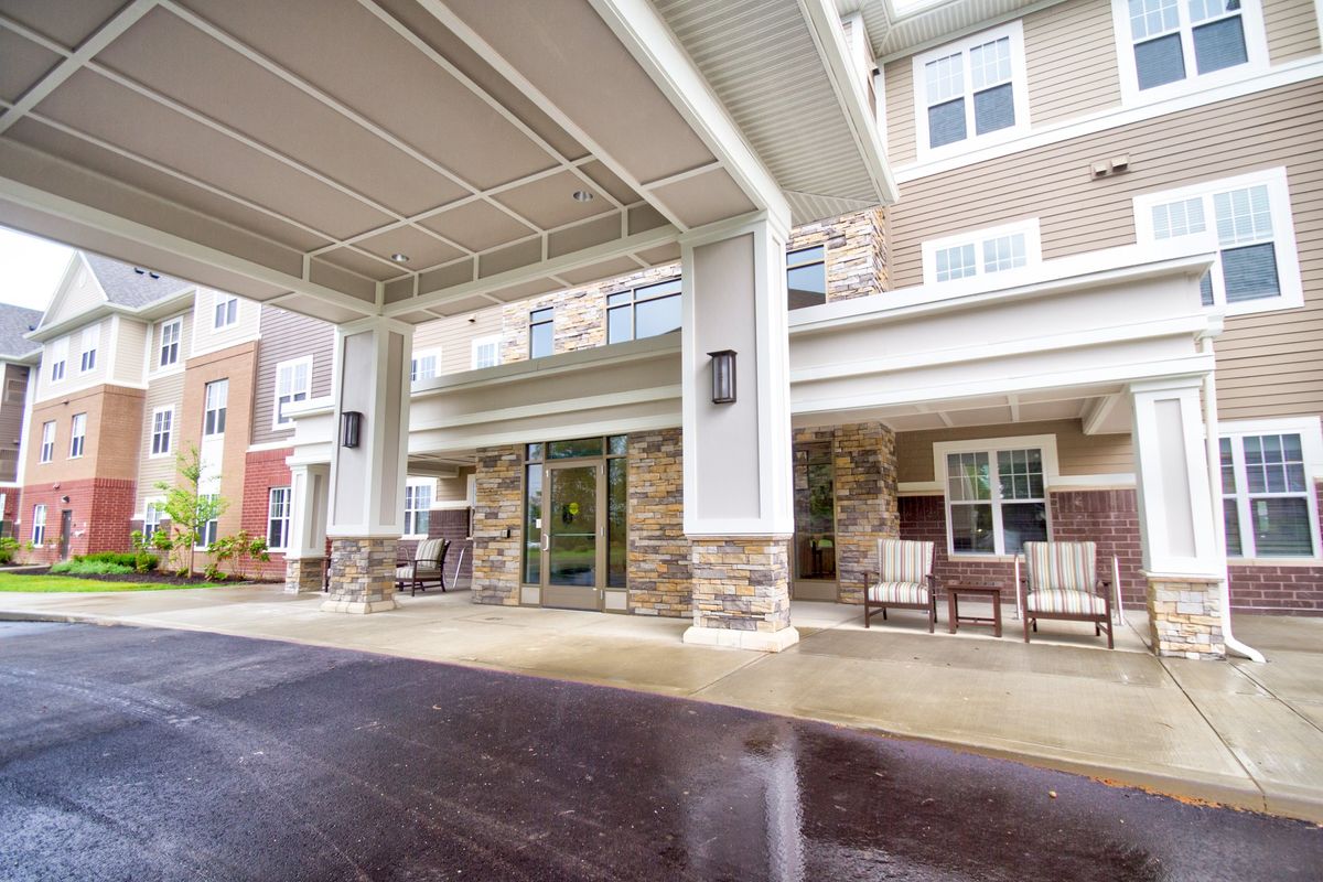 Covered entrance of a residential building with outdoor seating.