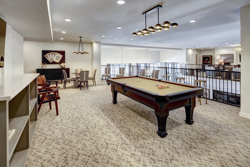 A modern game room featuring a pool table, comfortable seating, and stylish lighting.