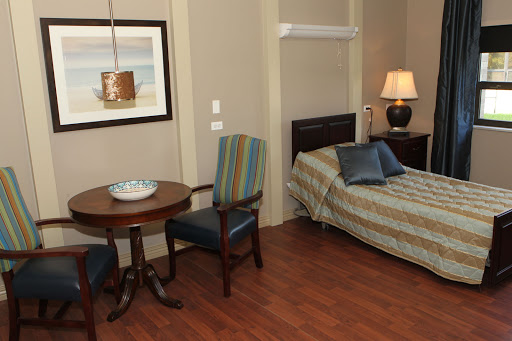 A well-furnished room featuring a bed, a dining table with chairs, and decorative elements.
