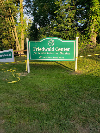 Sign of the Friedhold Center surrounded by greenery.