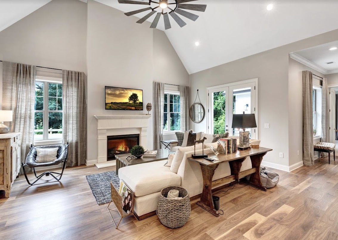 A spacious and elegantly designed living room with a fireplace, comfortable seating, and modern decor.