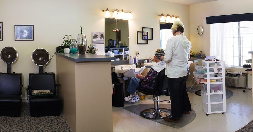 A hairdresser styling a client's hair in a salon setting.