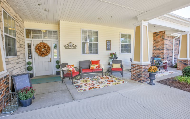 A cozy porch with seating and decorative elements creates a welcoming atmosphere.