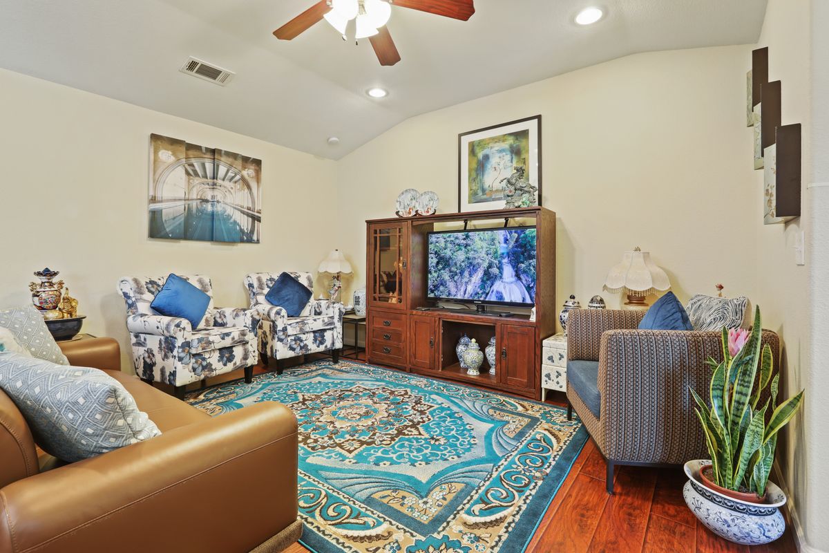 A cozy living room with comfortable seating, a television, and colorful decor.