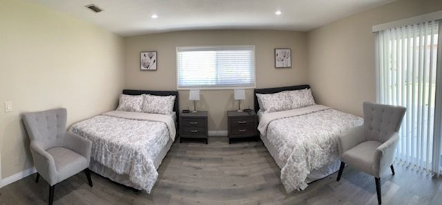 A modern bedroom with symmetrical twin beds and elegant decor.