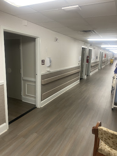 A view of a well-lit interior hallway with multiple doors and a clean floor.