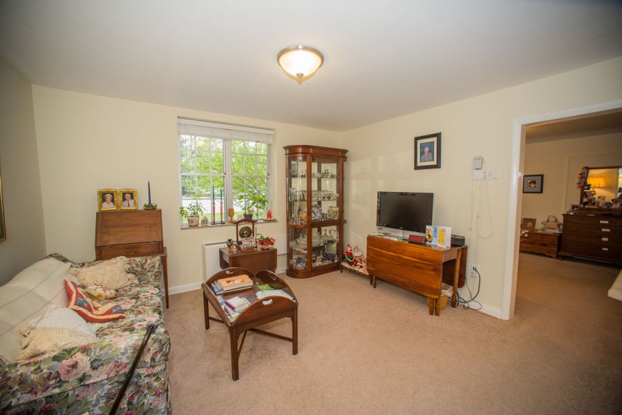 A cozy living room featuring a sofa, a wooden cabinet, and a television stand.