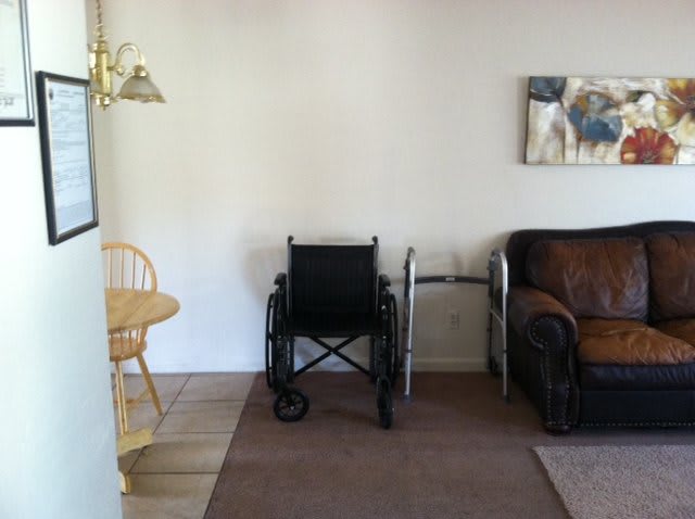 A living room area featuring a wheelchair, walker, and furniture.