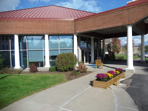 A modern building with a welcoming entrance and landscaped flower beds.