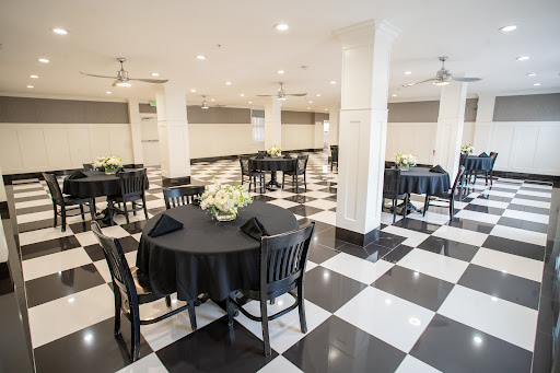 A spacious event space featuring black and white decor with elegantly set tables.