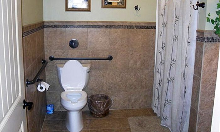 A bathroom with a toilet, tiled walls, and a shower curtain.