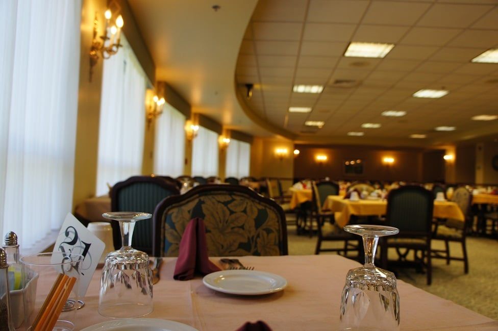 An elegant dining room in a restaurant with neatly arranged tables and chairs.