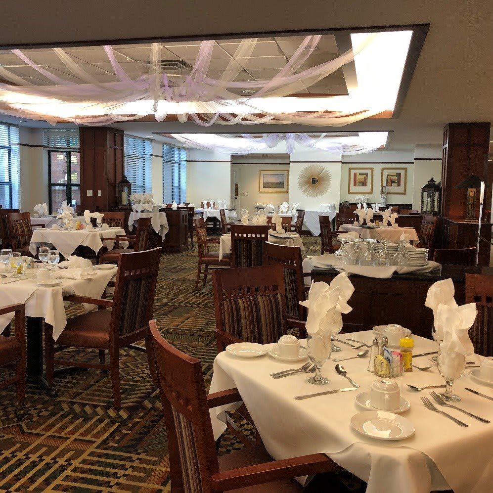 An elegant restaurant dining area with neatly arranged tables and chairs, set for guests.