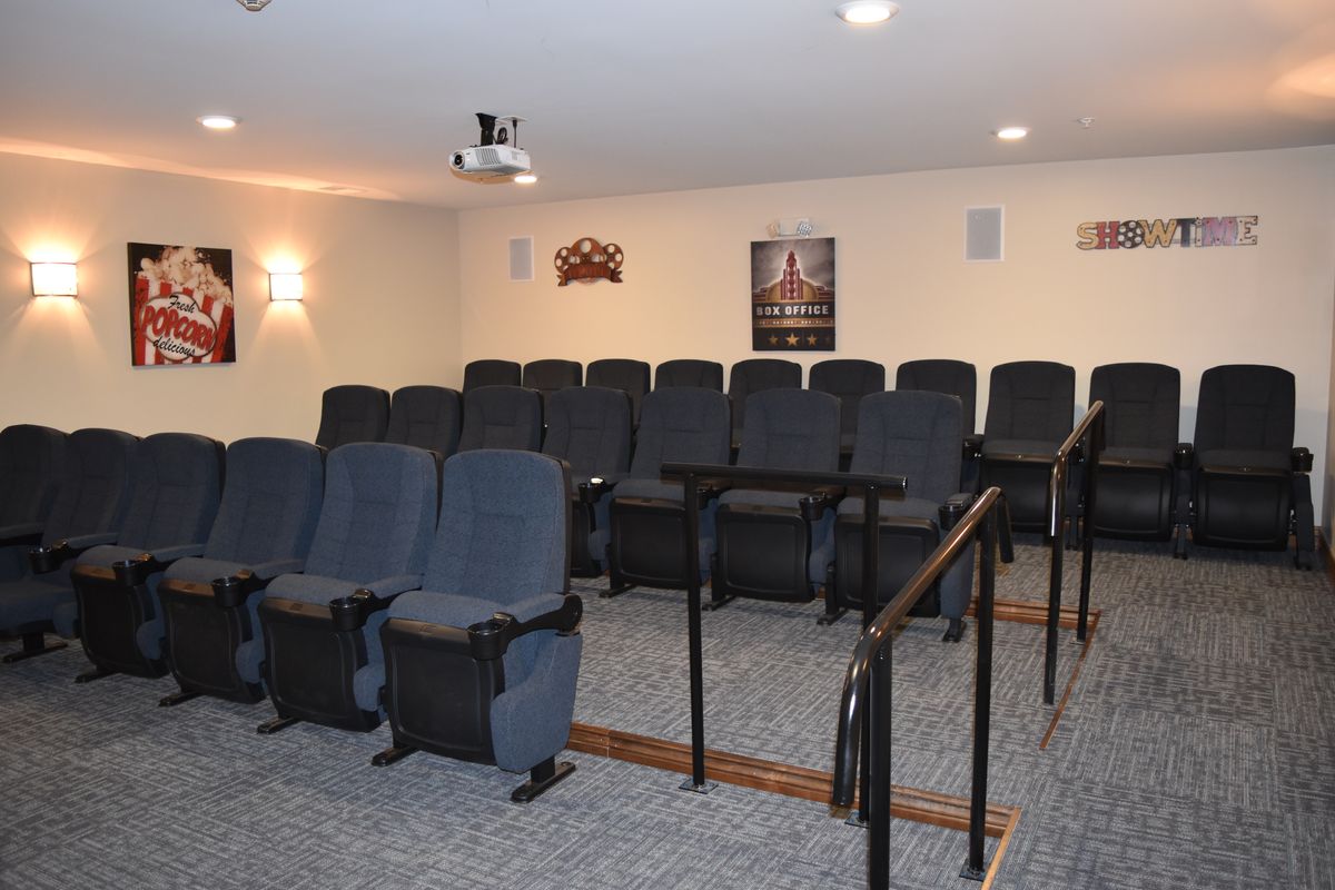 A home theater setup with tiered seating and a projector.