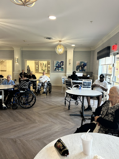 Residents enjoying time in the common area of a senior living facility.