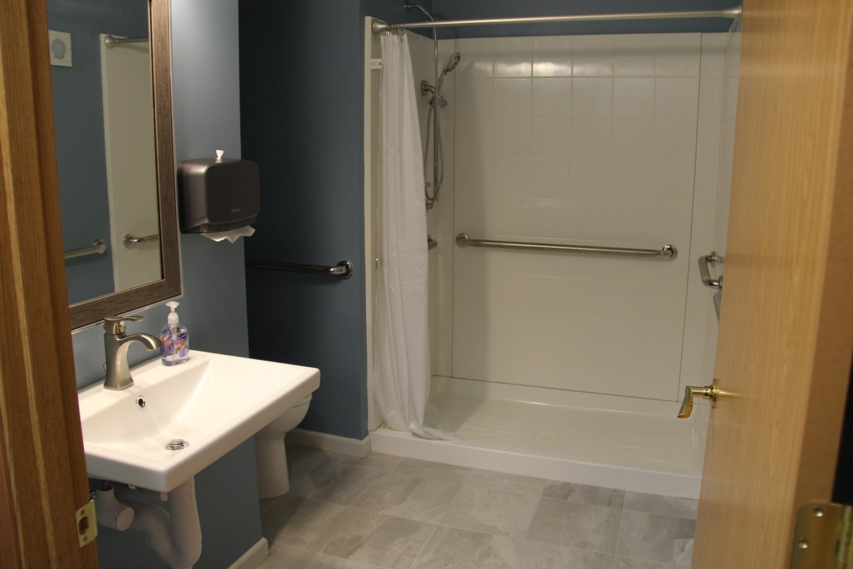An accessible bathroom with a walk-in shower and supportive grab bars.