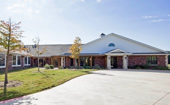 A spacious suburban house with a brick exterior and a wide driveway.