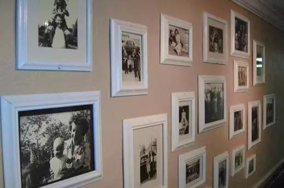A collection of framed black and white photos displayed on a wall, showcasing vintage moments.
