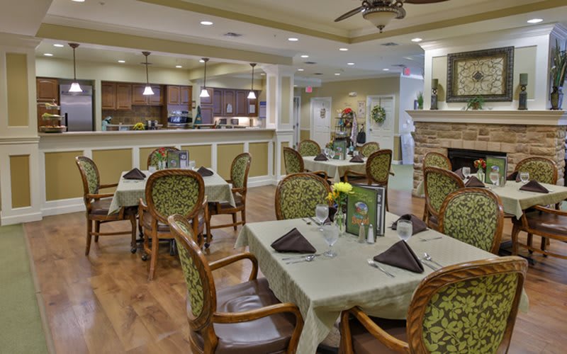 An elegant dining area with neatly arranged tables and chairs, warm lighting, and tasteful decor.