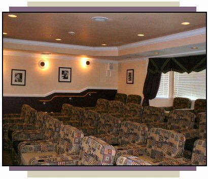 A cozy home theater with patterned seating and warm lighting.