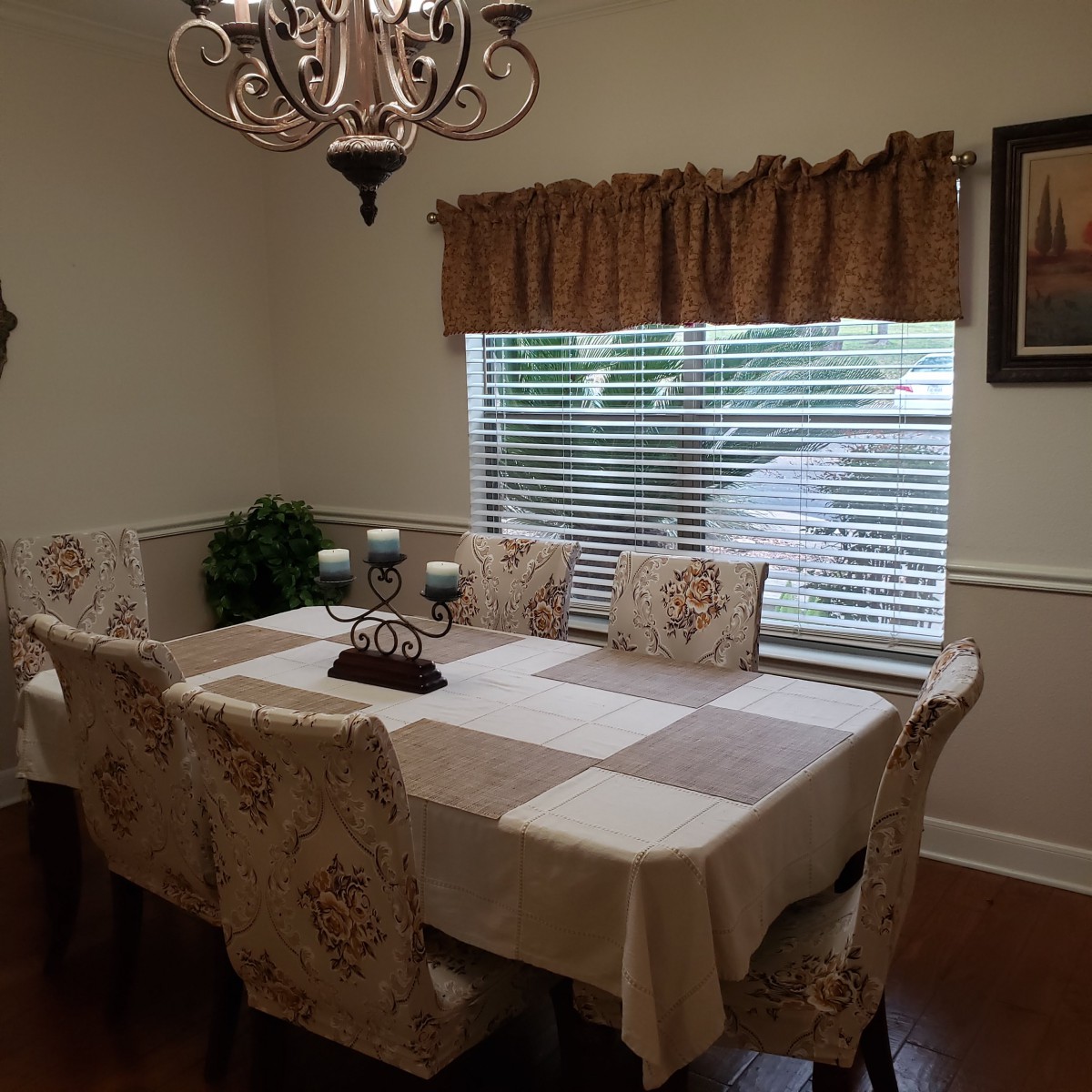 A cozy dining room with an elegant table setting and a chandelier.