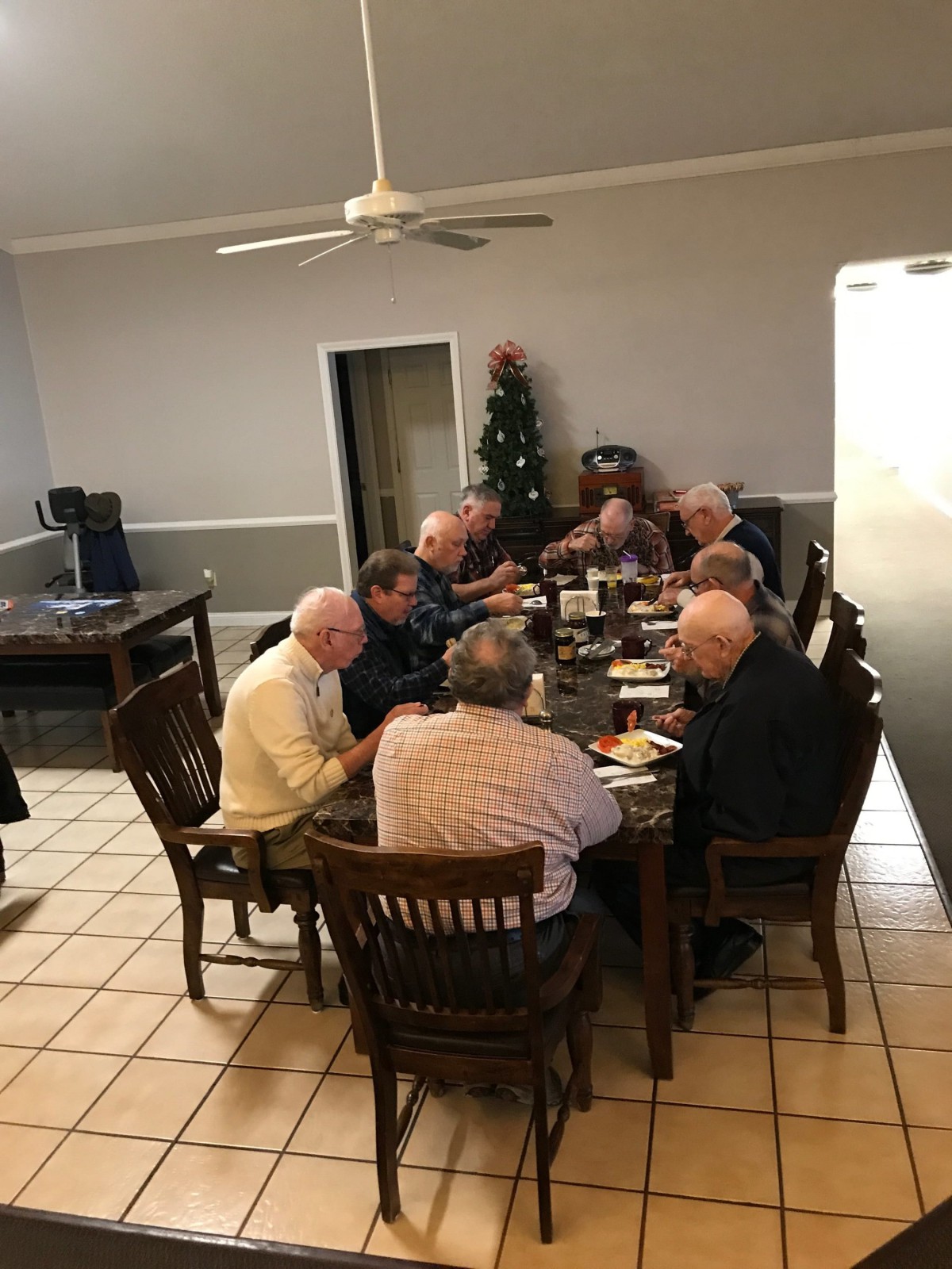 A group of people dining together around a table indoors.
