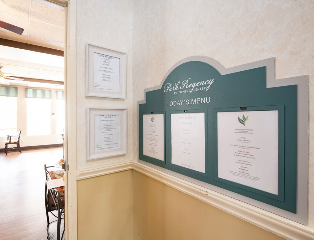 A restaurant interior featuring a wall-mounted menu and framed certificates.