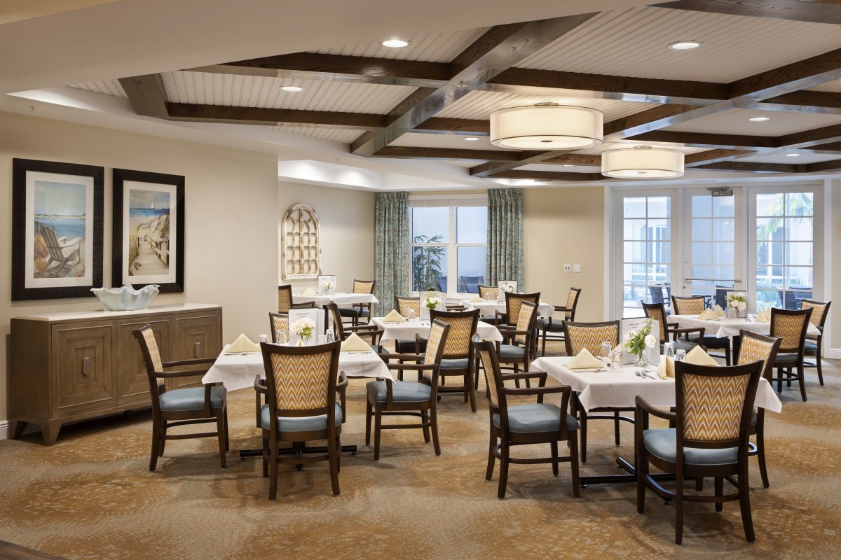 An elegant dining area with neatly arranged tables and chairs, decorated with tasteful lighting and decor.