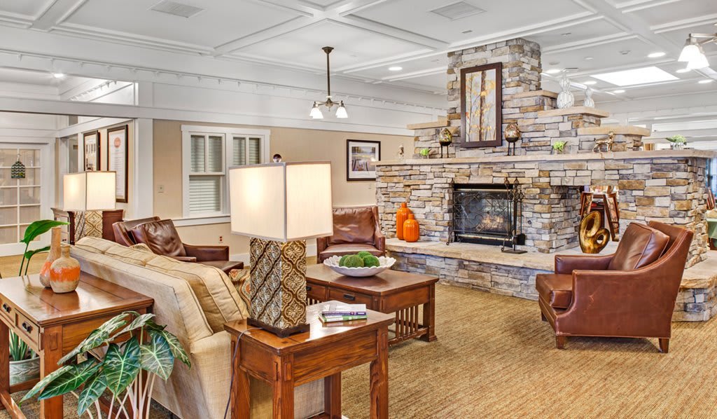 A cozy living room with a stone fireplace and comfortable seating.