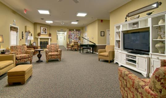 A cozy living room with comfortable seating, a television, and a piano.