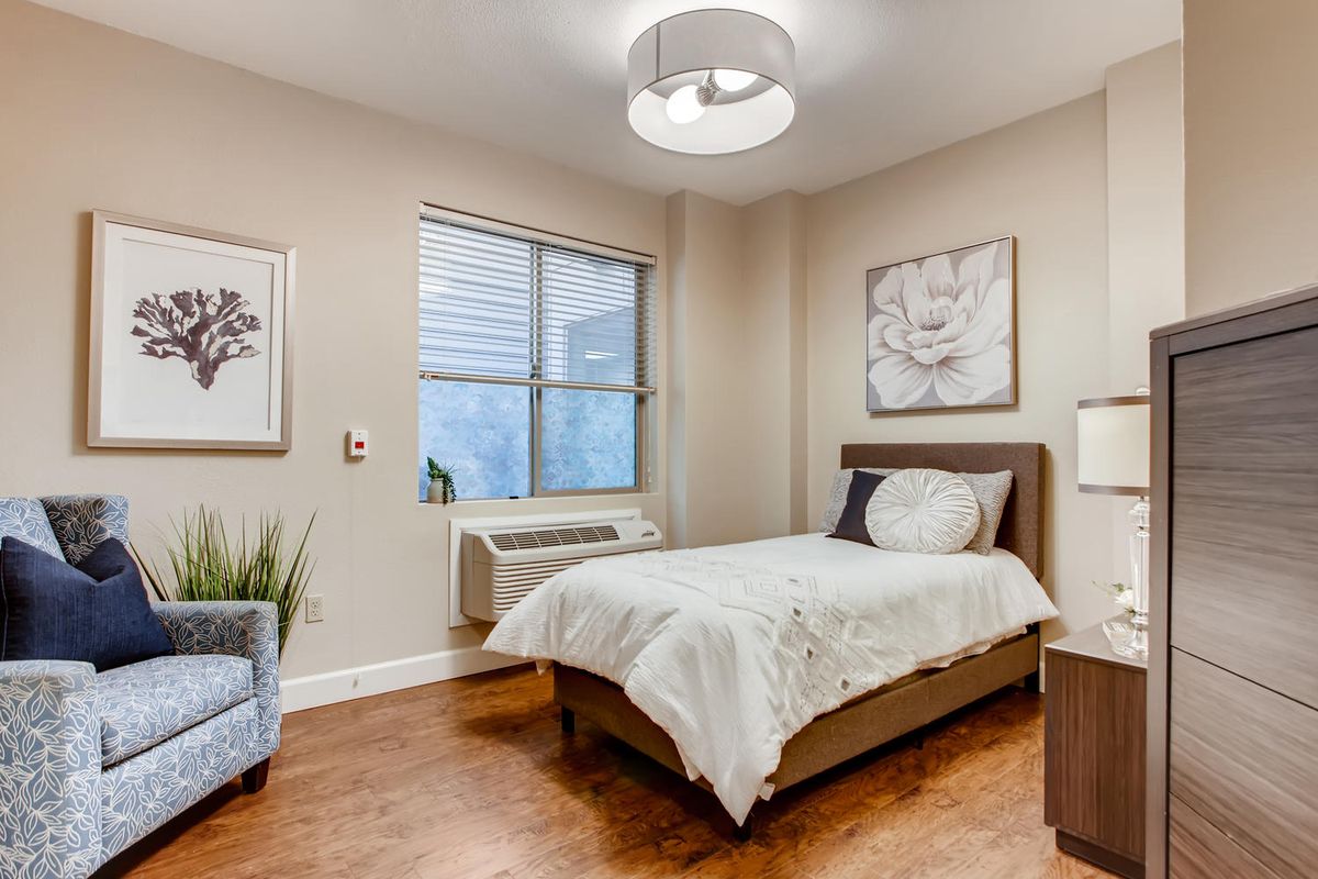 A modern, minimalist bedroom with a single bed and elegant decor.